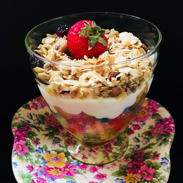 Granola with yoghurt and fresh fruit in a glass dish